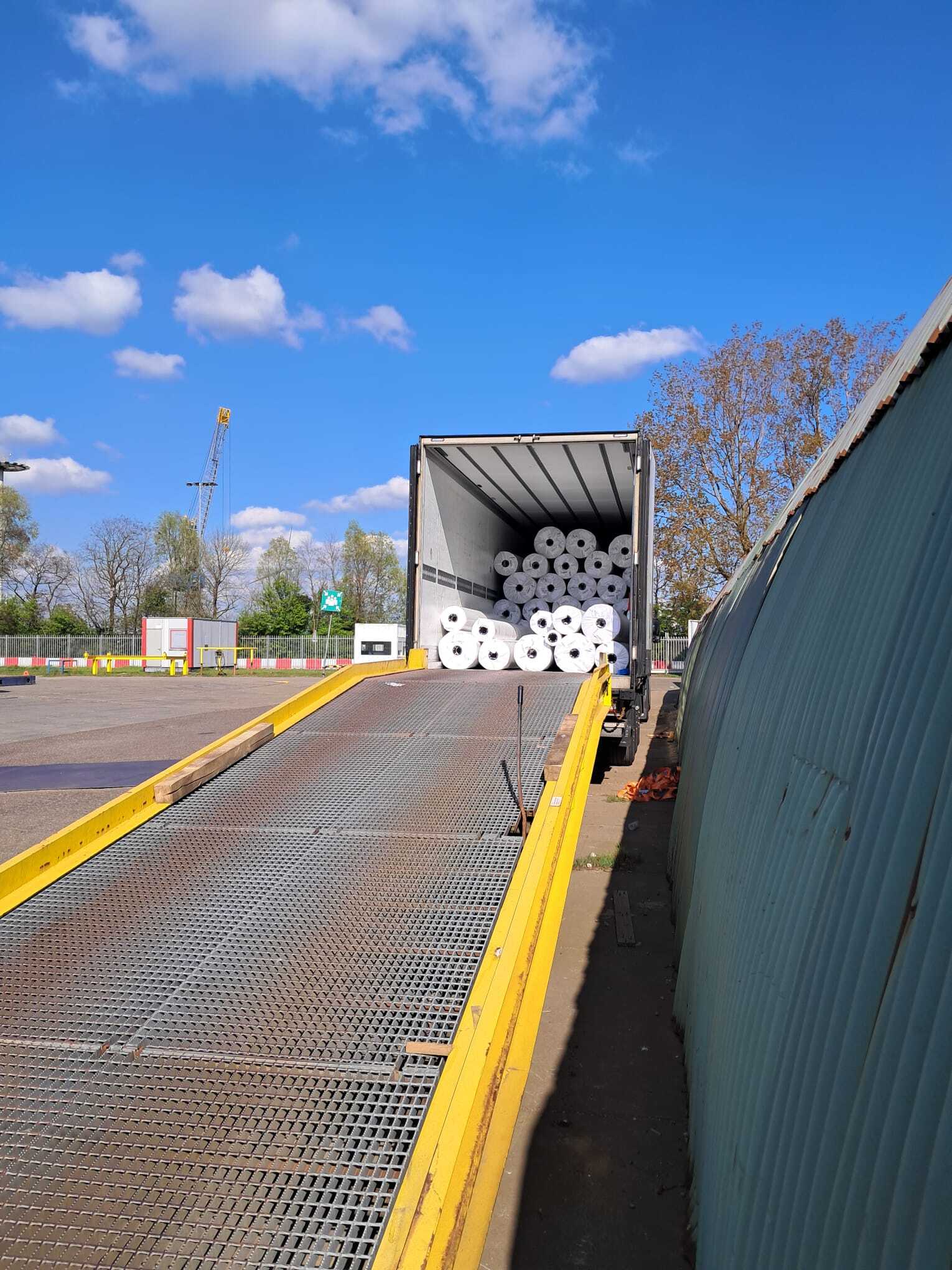 Laden van tapijtrollen voor internationaal transport van België naar Nederland door MileTrans.
